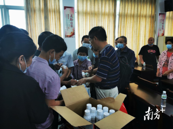 果树所专家团队向参加培训的果农派发新型农药药剂。  